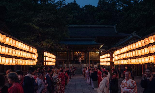 秋田の神社で行われる例祭、提灯と地域の人々が並ぶ夕暮れの境内